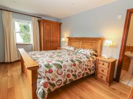 A bedroom with a bed and wardrobe at Ash House Ballyvaughan
