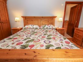 A bedroom with a bed and wooden furniture at Ash House in Ballyvaughan