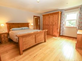 A bedroom with a bed and wardrobe at Ash House Ballyvaughan