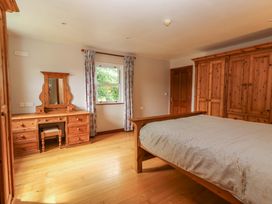 A bedroom with a bed and dressing table at Ash House in Ballyvaughan