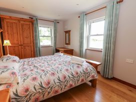 A bedroom with a bed and wardrobe at Ash House in Ballyvaughan