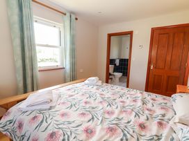 A bedroom with a bed and an adjoining bathroom at Ash House in Ballyvaughan