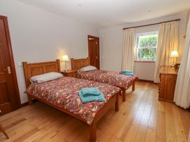 A bedroom with two beds and a window at Ash House Ballyvaughan