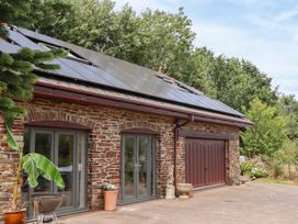 An outdoor view of a building with solar panels at Tigley Meadow Coach House in Totnes
