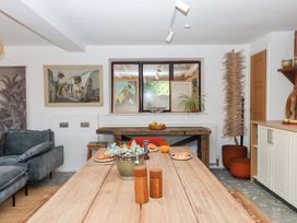 A dining room with a table and artworks at Tigley Meadow Coach House in Totnes