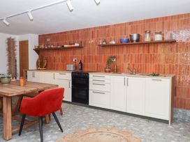 A kitchen with cabinets and dining area at Tigley Meadow Coach House in Totnes
