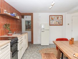 A kitchen with refrigerator, sink, stove and dining table at Tigley Meadow Coach House in Totnes