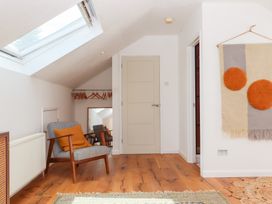 An attic space with a skylight and a chair at Tigley Meadow Coach House in Totnes