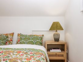 A bedroom with a bed and a nightstand at Tigley Meadow Coach House in Totnes