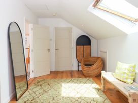 A room with a mirror, doors, chair and table at Tigley Meadow Coach House, Totnes