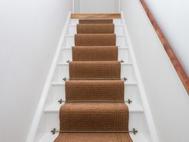 A staircase with a carpet runner at Tigley Meadow Coach House in Totnes