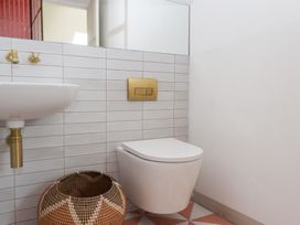 A bathroom with a toilet, sink, and mirror at Tigley Meadow Coach House in Totnes