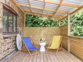 A patio with two chairs and a table at Tigley Meadow Coach House in Totnes