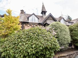A house exterior with bushes and trees at School Cottage in Windermere
