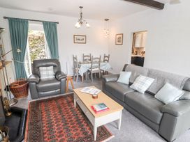 A living room with a sofa and dining area at School Cottage in Windermere