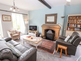A living room with a fireplace and television at School Cottage in Windermere