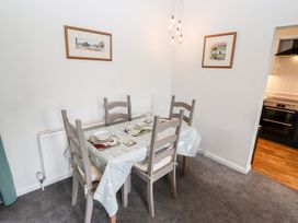 A dining room with a table and chairs at School Cottage in Windermere