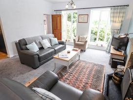 A living room with a sofa and television at School Cottage in Windermere