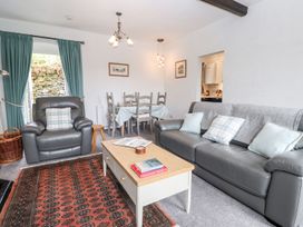 A living room with a sofa and dining area at School Cottage in Windermere