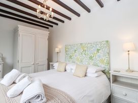 A bedroom with a bed and wardrobe at School Cottage in Windermere
