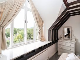 A bedroom with a window and dressing table at School Cottage in Windermere