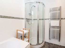 A bathroom with a shower and towel rack at School Cottage in Windermere