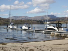 A dock with boats on the water at School Cottage in Troutbeck Bridge near Windermere