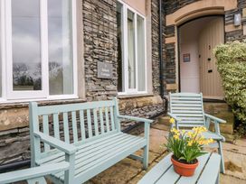 An outdoor area with benches and flowers at School Cottage in Troutbeck Bridge near Windermere