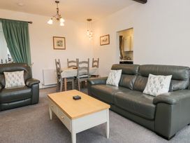 A living room with a sofa and dining table at School Cottage, Troutbeck Bridge near Windermere