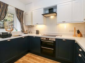 A kitchen with dark blue cabinets and appliances at School Cottage near Troutbeck Bridge