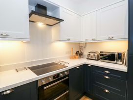 A kitchen with an oven, stove, microwave, and toaster at School Cottage in Troutbeck Bridge near Windermere