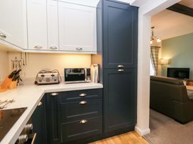 A kitchen with appliances and storage at School Cottage Troutbeck Bridge near Windermere