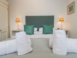 A bedroom with a bed and towels at School Cottage in Troutbeck Bridge near Windermere