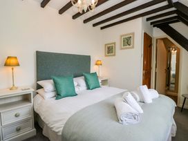 A bedroom with a bed and bedside table at School Cottage in Troutbeck Bridge near Windermere