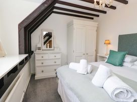 A bedroom with a bed and a dressing table at School Cottage Troutbeck Bridge near Windermere