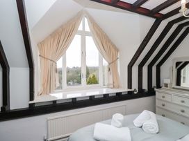 A bedroom with a window and towels arranged on a bed at School Cottage Troutbeck Bridge near Windermere