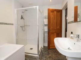 A bathroom featuring a shower, bathtub, and sink at School Cottage, Troutbeck Bridge near Windermere
