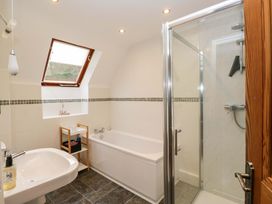 A bathroom with a bathtub and shower at School Cottage in Troutbeck Bridge near Windermere