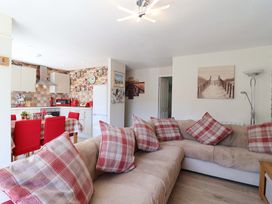 A living room with a sofa and dining area at Boo’s Bungalow in Callington near Gunnislake