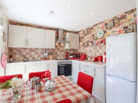 A kitchen with appliances and a table at Boo’s Bungalow in Callington near Gunnislake