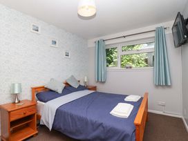 A bedroom with a bed and nightstand at Boo’s Bungalow in Callington near Gunnislake