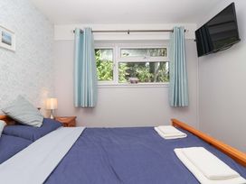 A bedroom with a bed and a television at Boo’s Bungalow in Callington near Gunnislake