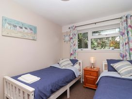 A bedroom with two single beds and a side table at Boo’s Bungalow near Callington