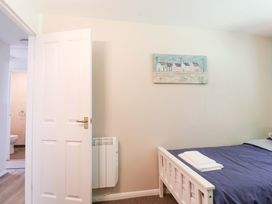 A bedroom with a bed and towels at Boo’s Bungalow in Callington near Gunnislake