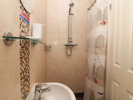 A bathroom with a shower and washbasin at Boo’s Bungalow Callington near Gunnislake