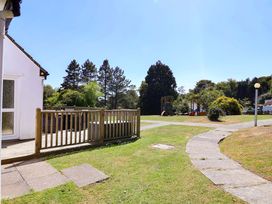 An outdoor area with decking and a playground at Boo’s Bungalow Callington near Gunnislake