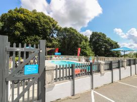 An outdoor pool area with a fence and seating at Boo’s Bungalow in Callington near Gunnislake
