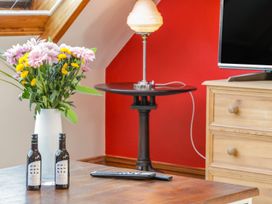 A living room with flowers and a lamp on a side table at Atelier in Bridlington