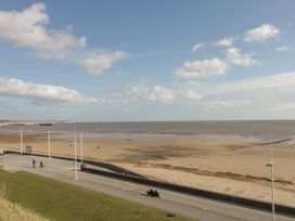 A beach with people walking near the sea at Atelier in Bridlington
