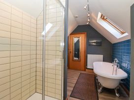 A bathroom with a shower, a bathtub, and a radiator at Atelier in Bridlington
